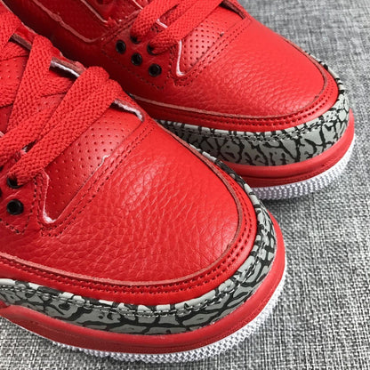 Close-up view of the red upper and patterned toe overlay on the pair.