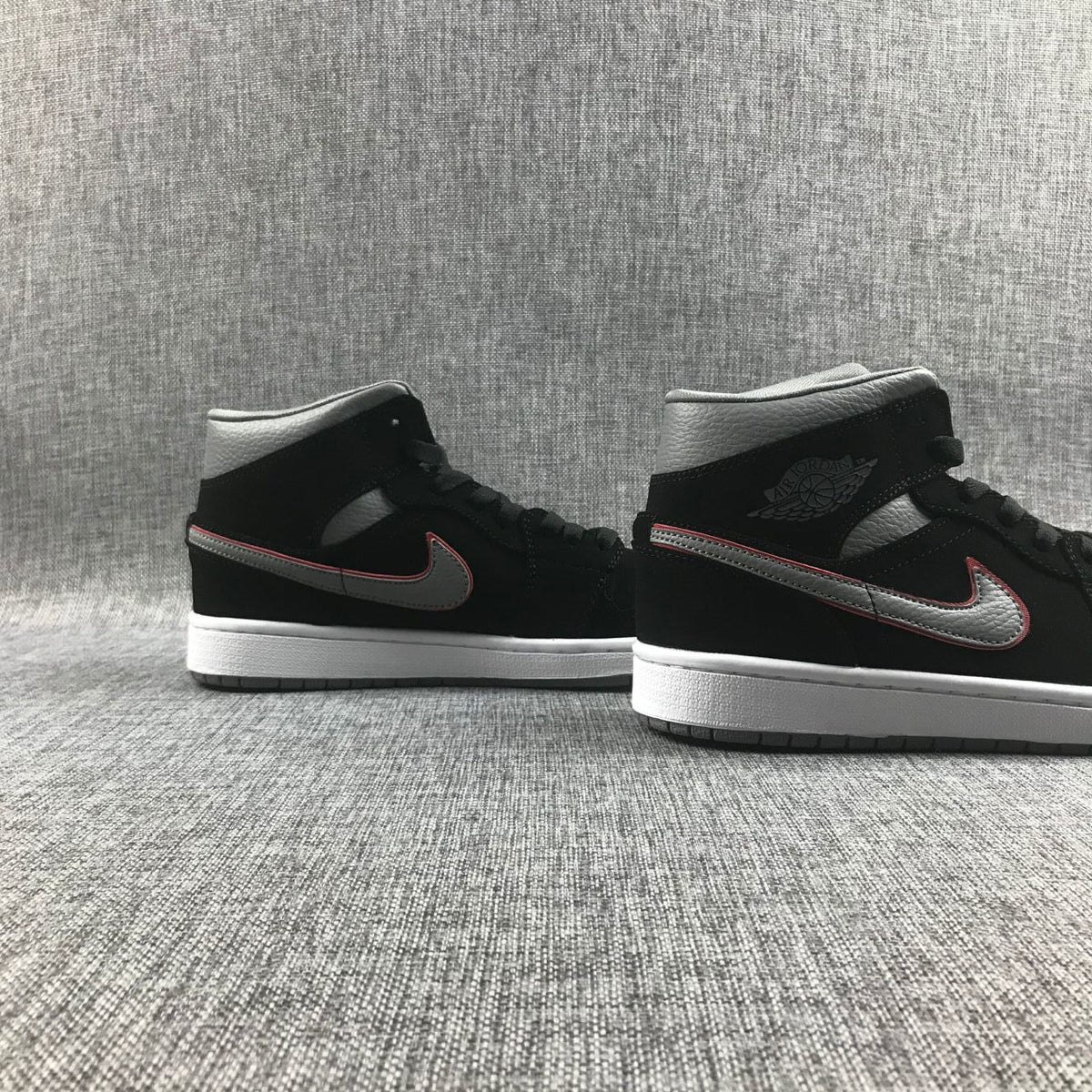 Rear-side view of the pair highlighting the grey collar panels, black heel sections and white midsoles.