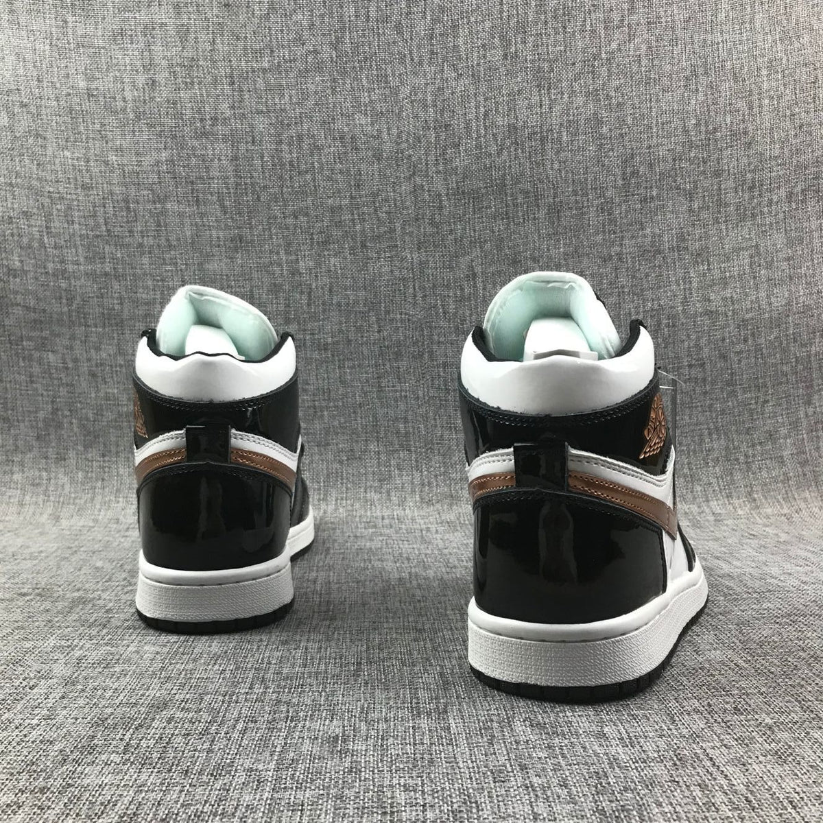 Rear view of the pair showing black heel panels, white midsoles and metallic-gold accent strips.