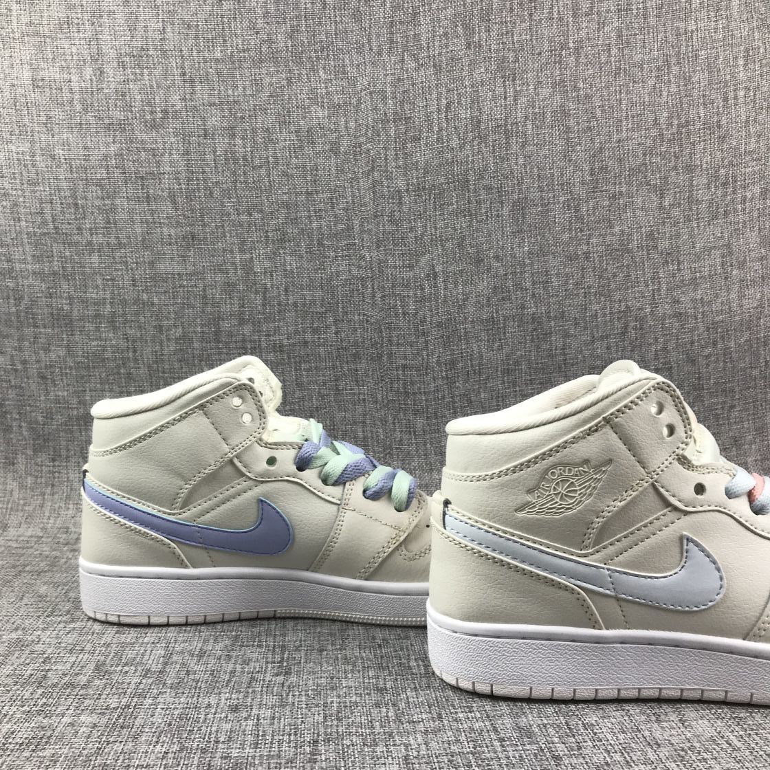 Side view of the pair showing the embossed winged branding and contrasting pastel Swooshes.