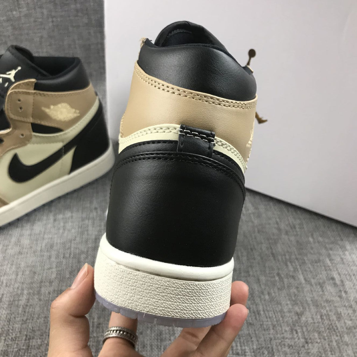 Close-up rear view showing the black collar, beige upper, and white midsole.