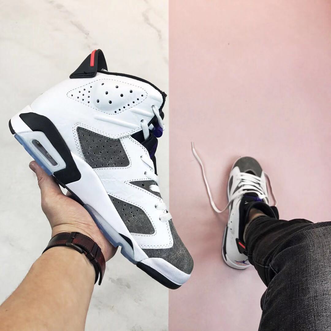 Side profile showing the perforated white upper, grey panels, black midsole accents, red heel detail, and translucent outsole.