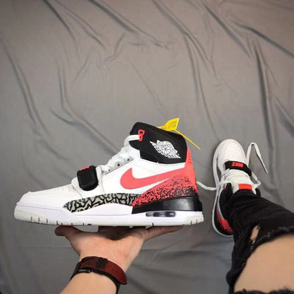 Side view of a white, black, and red high-top sneaker with a forefoot strap, elephant-print panel, and visible midsole window.