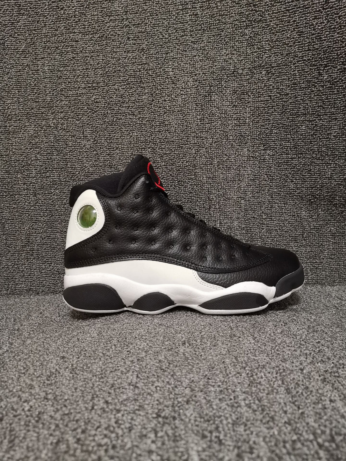 Side profile showing the black upper, white midsole, and circular heel detail
