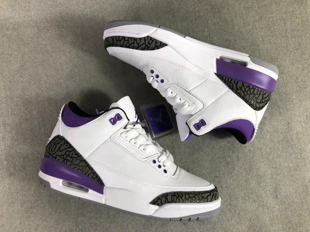 Overhead view of the pair showing the white uppers, purple accents, dark patterned overlays, and midsoles.