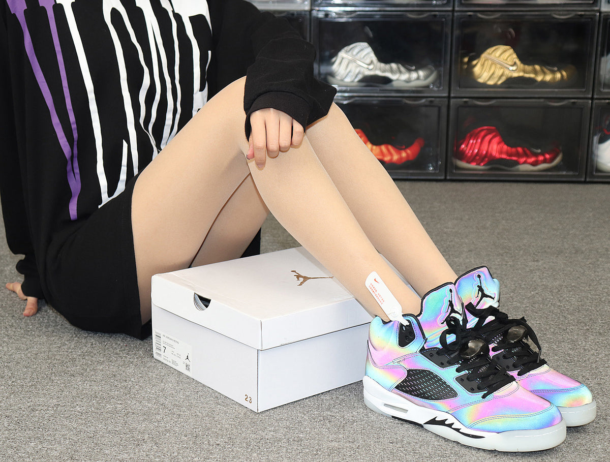Lifestyle view of the iridescent sneakers worn with a white Jordan shoebox.
