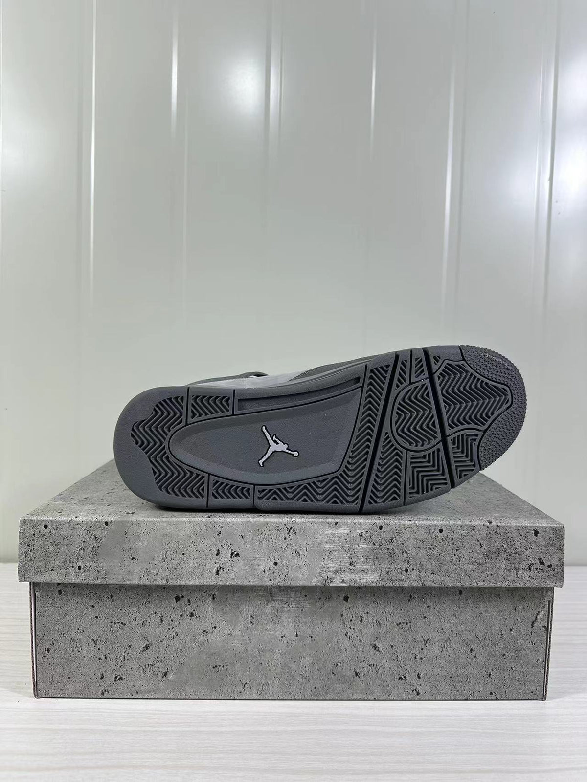 Bottom view of the sneaker showing the dark rubber outsole and herringbone-style traction pattern.