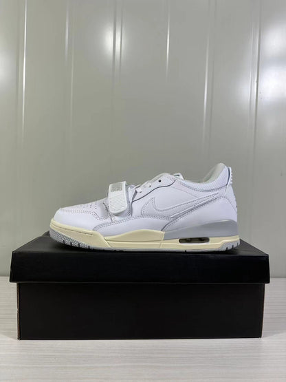 Side profile showing the white upper, forefoot strap, layered panels, visible midsole air window, and cream outsole accents.