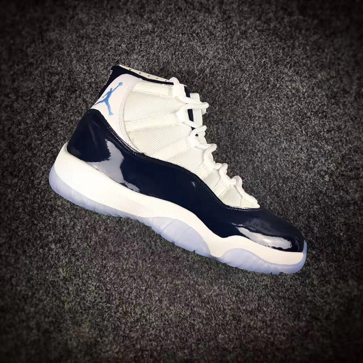 Side view of one navy and white high-top sneaker with its translucent outsole visible.
