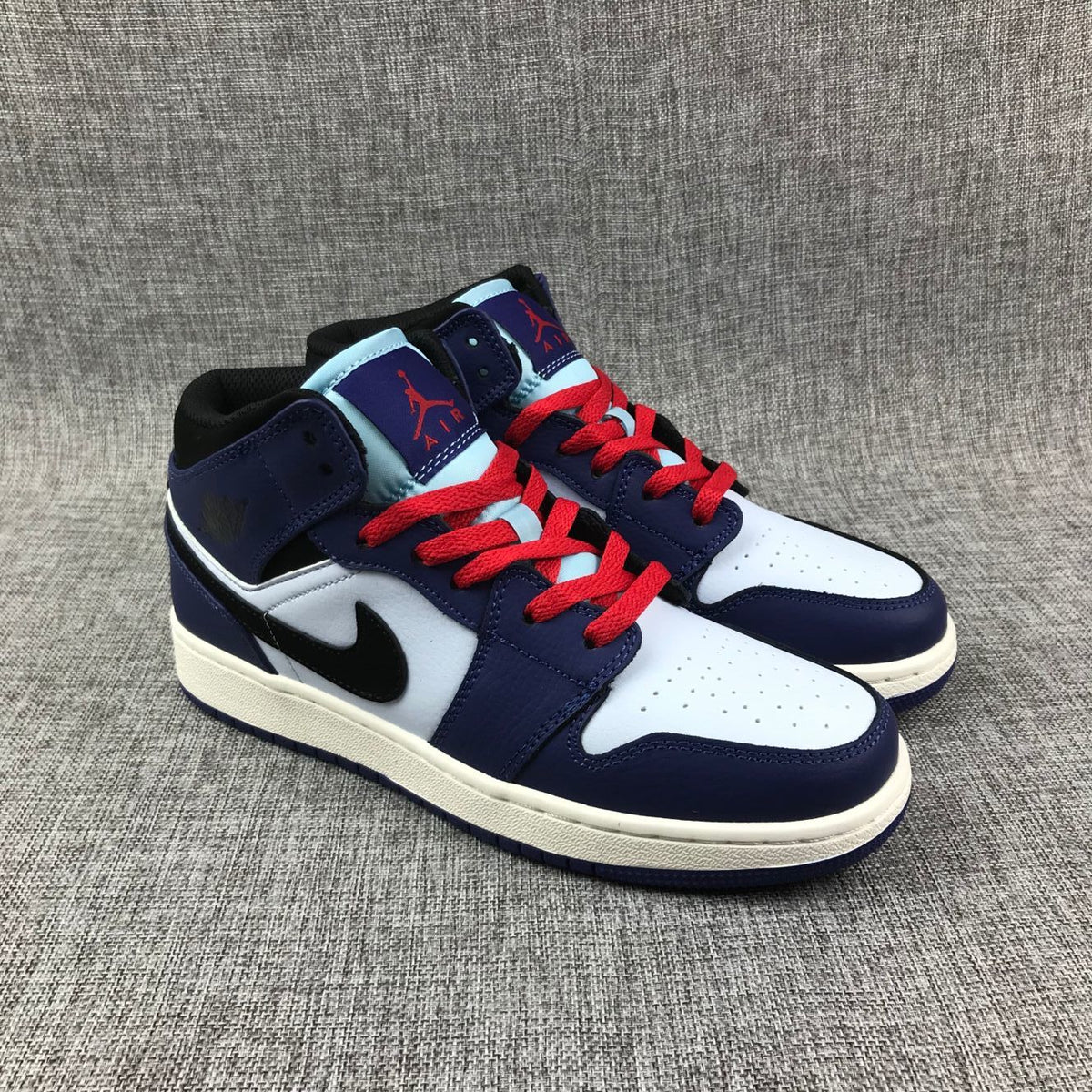 Three-quarter front view of the pair with white toe boxes, purple overlays and red laces.