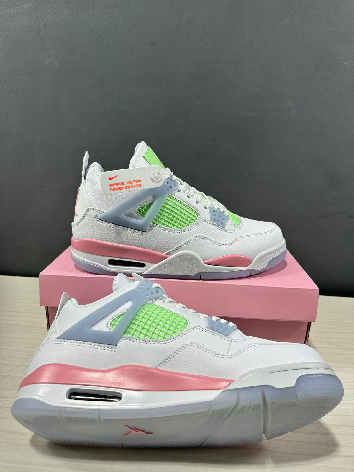 Close angled view highlighting the white upper, lime green mesh, pink midsole, and translucent outsole edge.