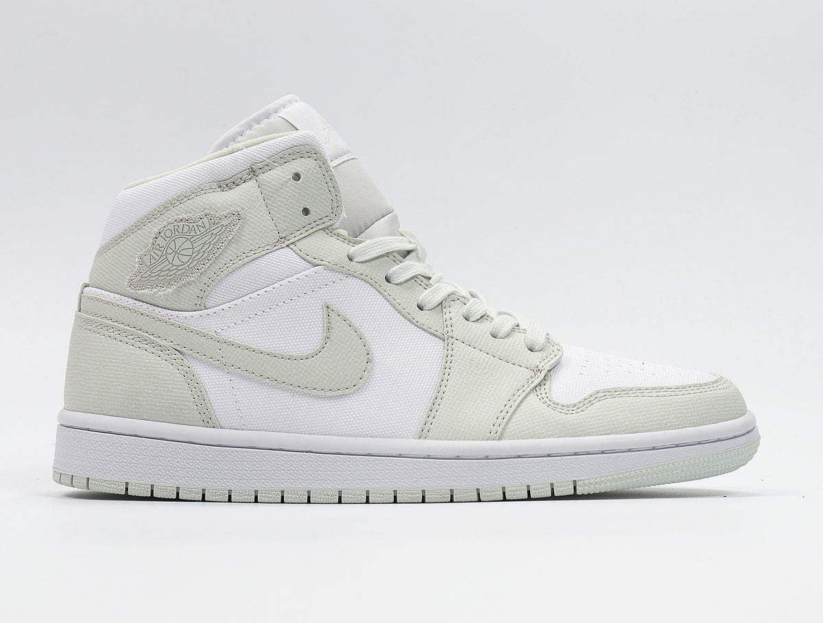 Side view of the sneaker displaying the Jordan Wings logo, Swoosh, lace-up construction, and color blocking.