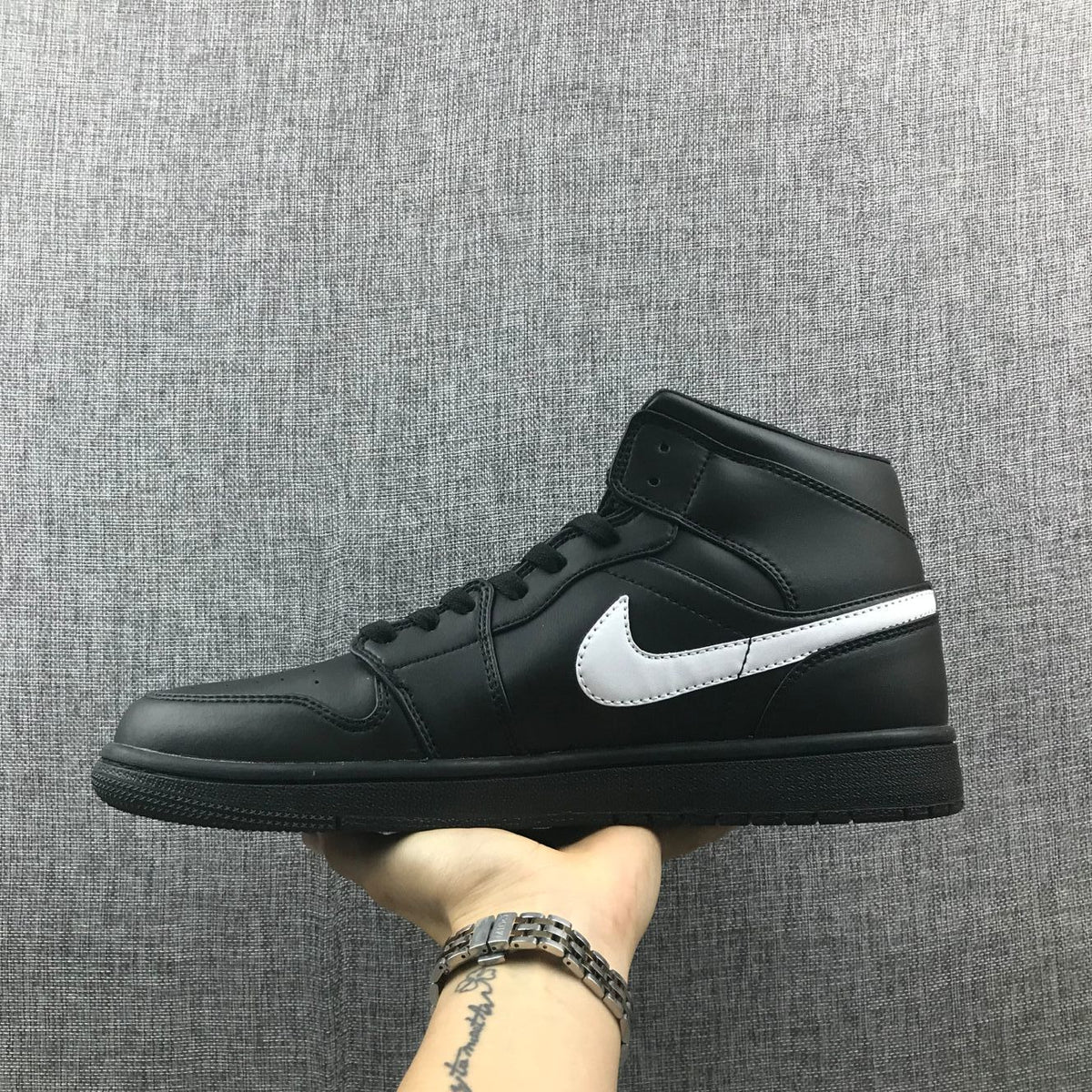 Opposite side profile showing the black upper, white Swoosh and black rubber outsole.