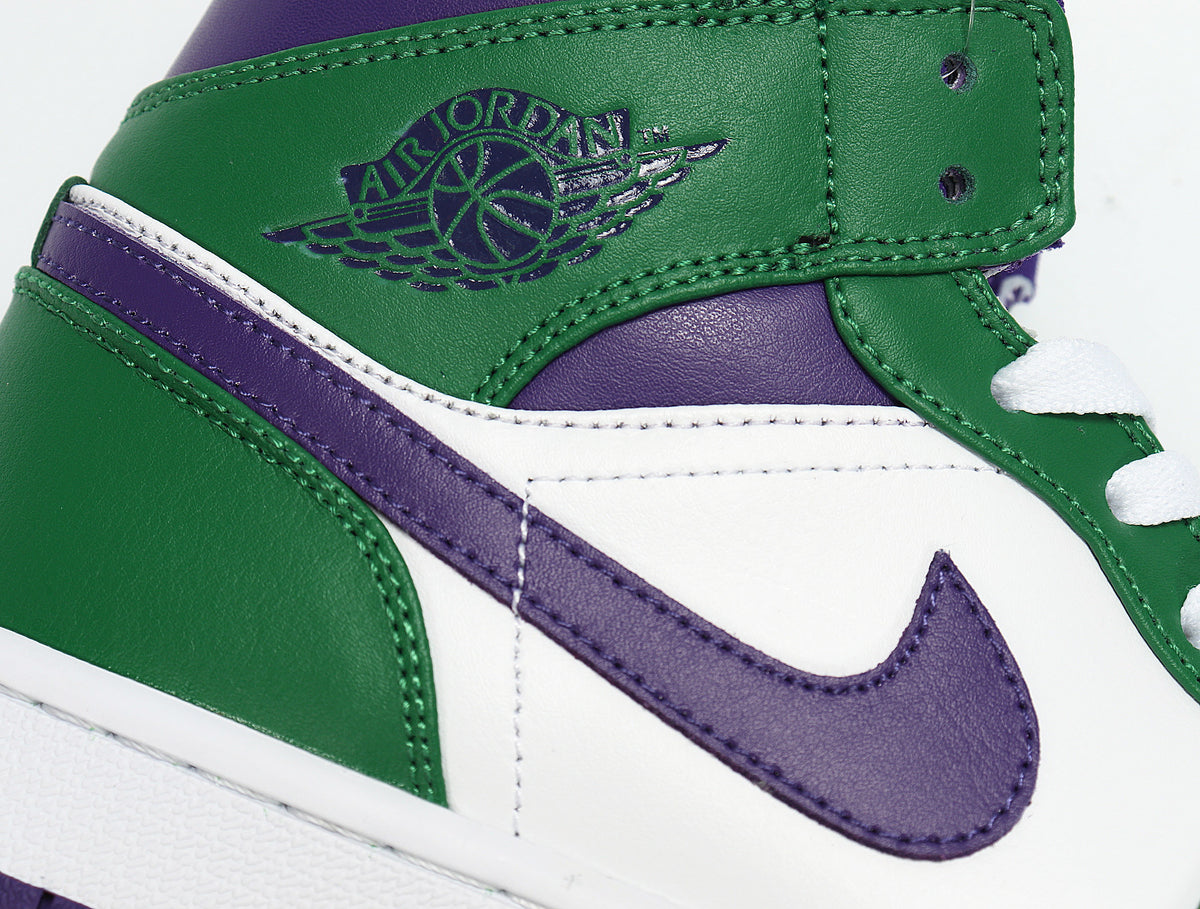 Close-up of a green, white and purple high-top sneaker with a purple Swoosh and Jordan Wings branding.