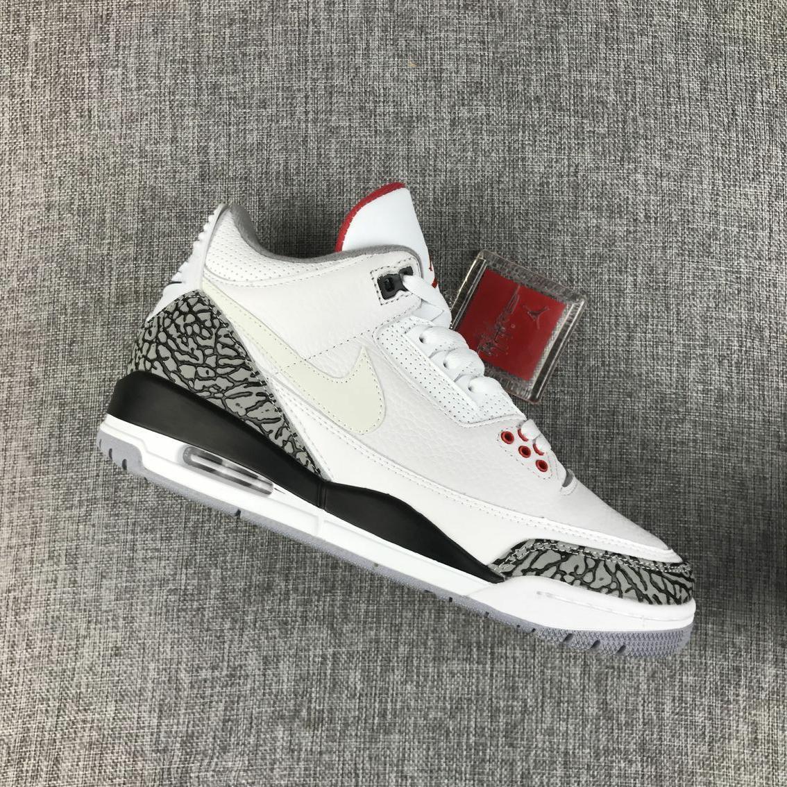 Angled view of the white and grey Jordan sneaker showing the elephant-print heel and toe panels.