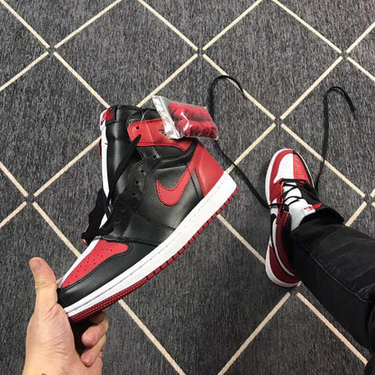 Angled view of a black and red high-top sneaker with a clear accessory package near the collar.