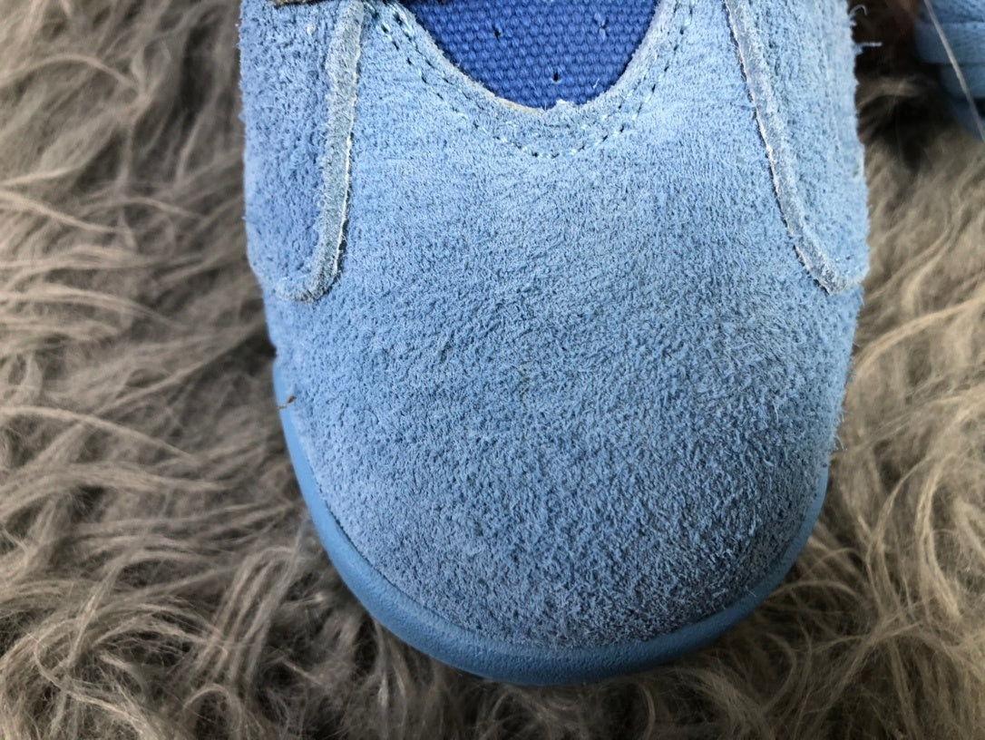 Close-up view of the textured sky blue toe box and stitched paneling.