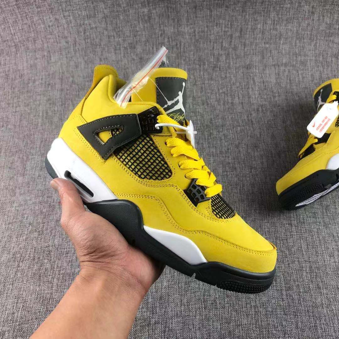 Close-up of a yellow and black high-top sneaker showing the side mesh panel, lace system, white midsole, and black outsole.