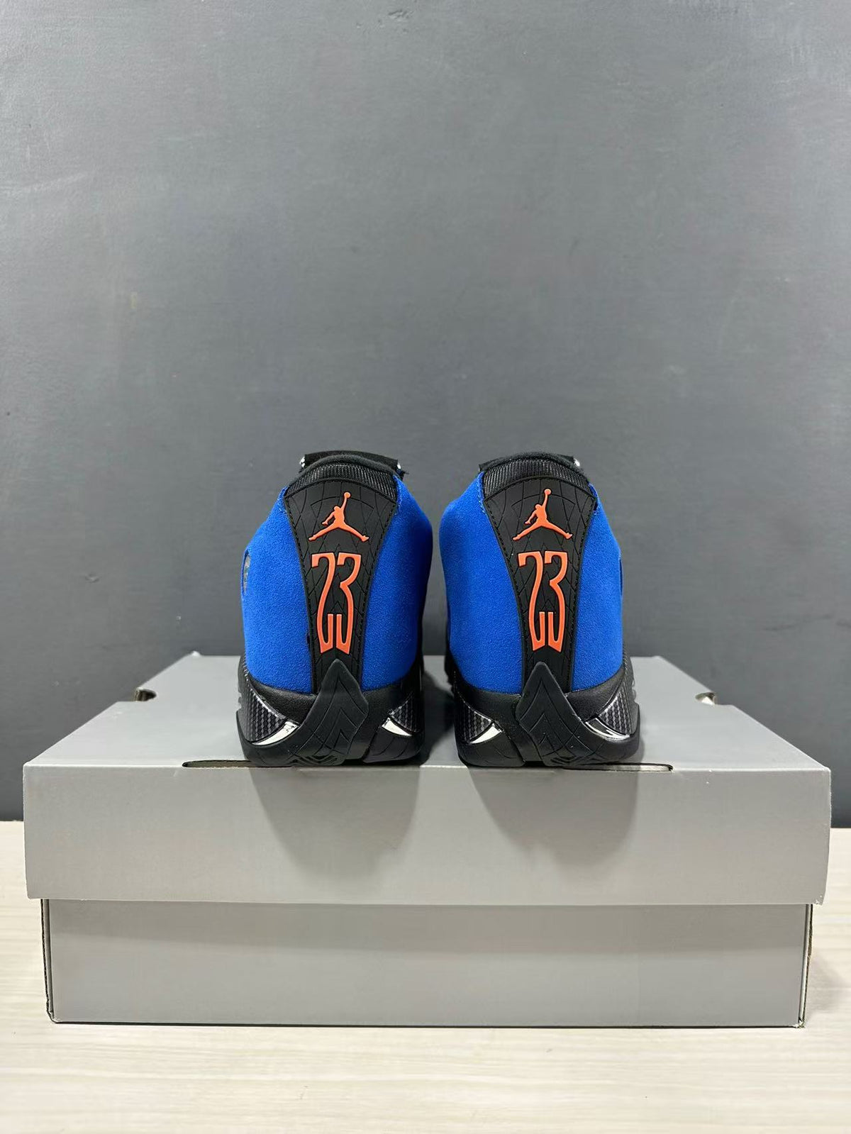 Rear view of the pair showing orange Jordan branding and the number 23 on black heel panels.