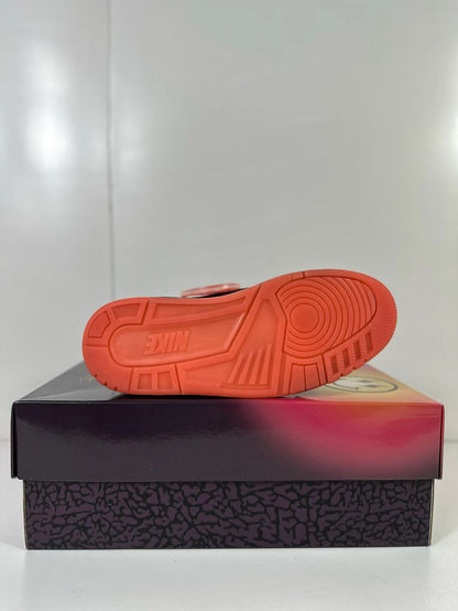 Bottom view showing the coral-red outsole and its circular and geometric traction pattern.