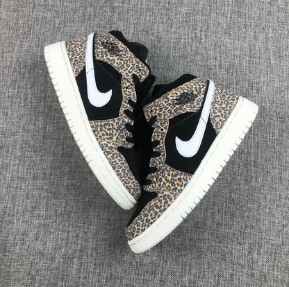 Top-down view of the pair showing leopard-print overlays, black panels, white Swooshes, and white outsoles.