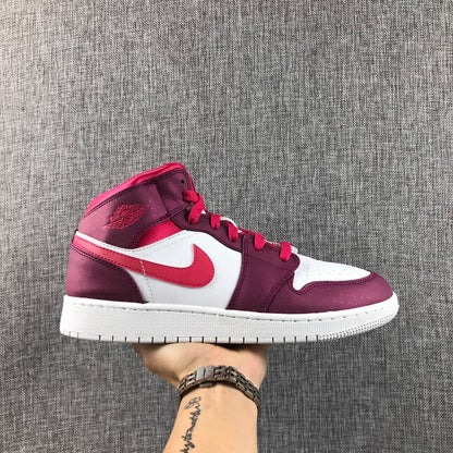 Side profile of the sneaker held against a gray textured background.