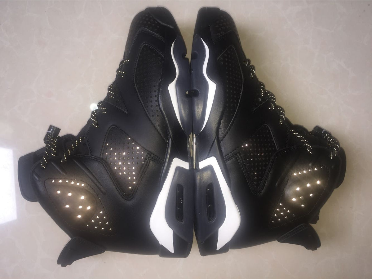 Overhead view of the paired sneakers showing the black upper, white midsole accents, and side-panel perforations.