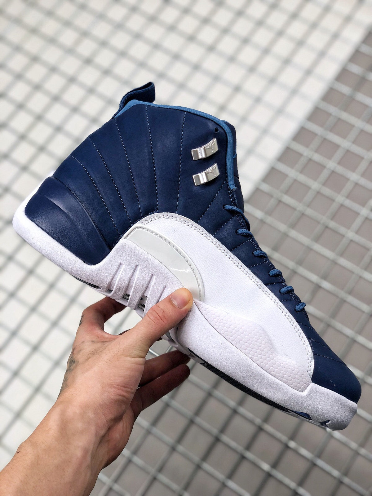 Side profile of the indigo and white sneaker showing the padded high-top collar, stitched panels, and white midsole.