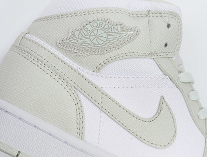 Close-up of the light Spruce Jordan Wings logo, Swoosh, stitching, and textured overlays.