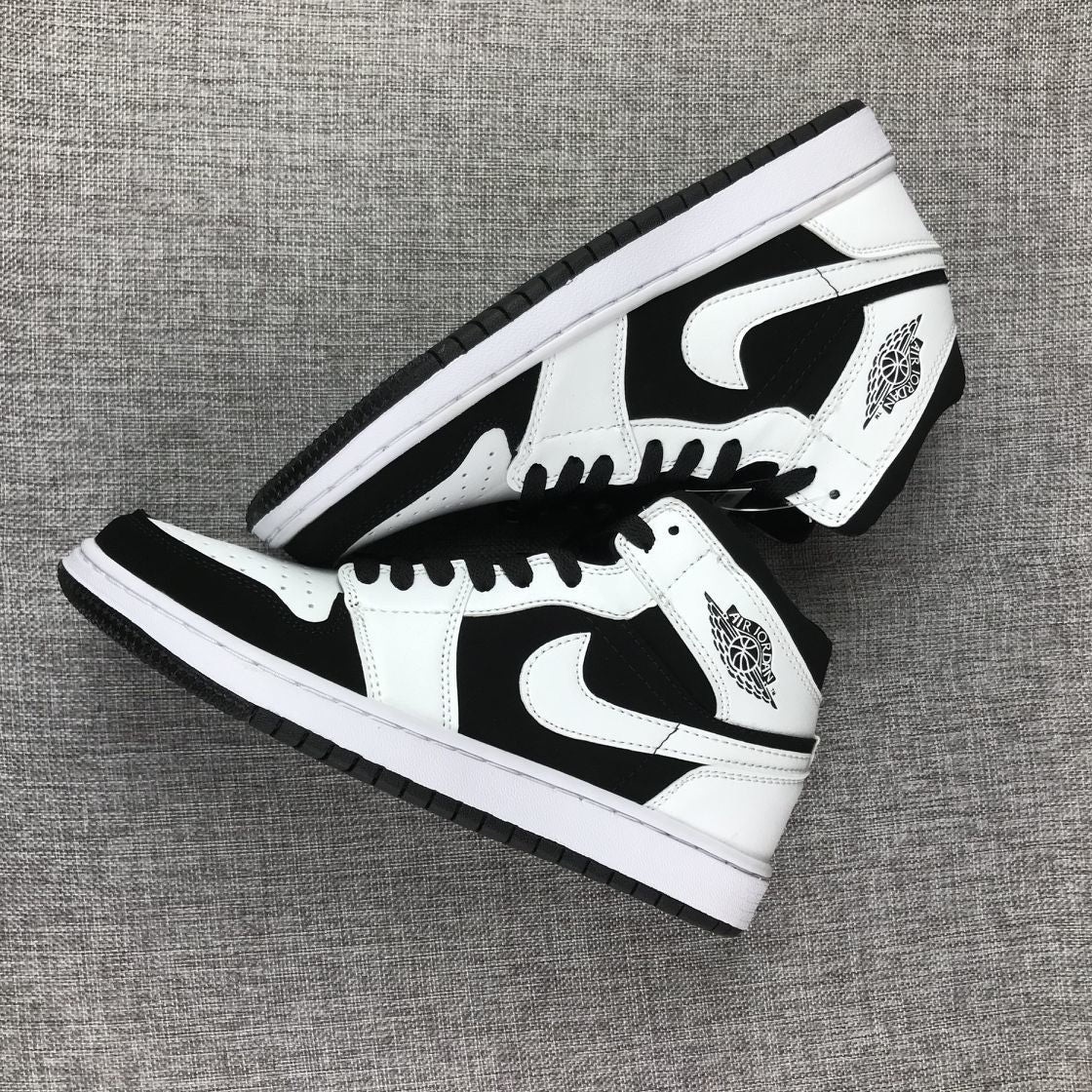 Two black-and-white high-top sneakers arranged diagonally to show their side panels and outsoles.