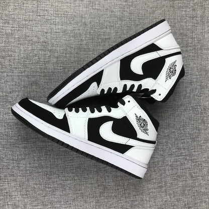 Two black-and-white high-top sneakers arranged diagonally to show their side panels and outsoles.