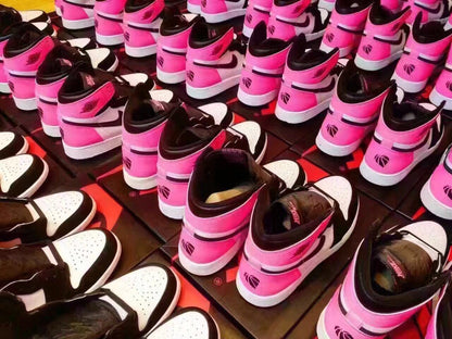Multiple pairs of the pink, black, and white high-top sneakers displayed together.