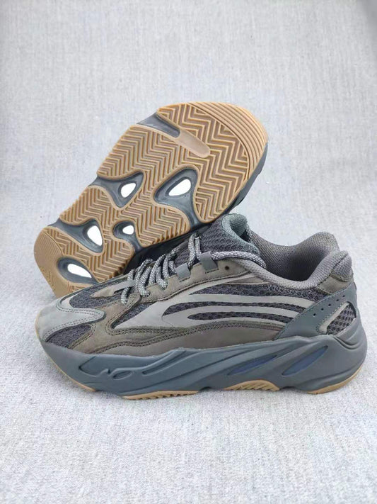 Gray 700 V2-style sneaker shown from the side with the gum-colored outsole visible underneath.