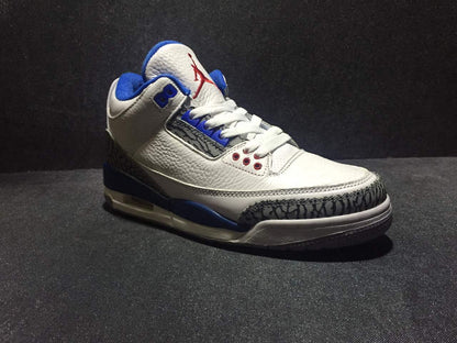 Front three-quarter view of the white and blue high-top sneaker with red tongue branding and elephant-print toe overlay.