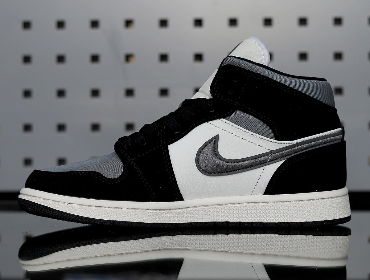 Side profile showing the black and grey Swoosh, white side panel and layered midsole.