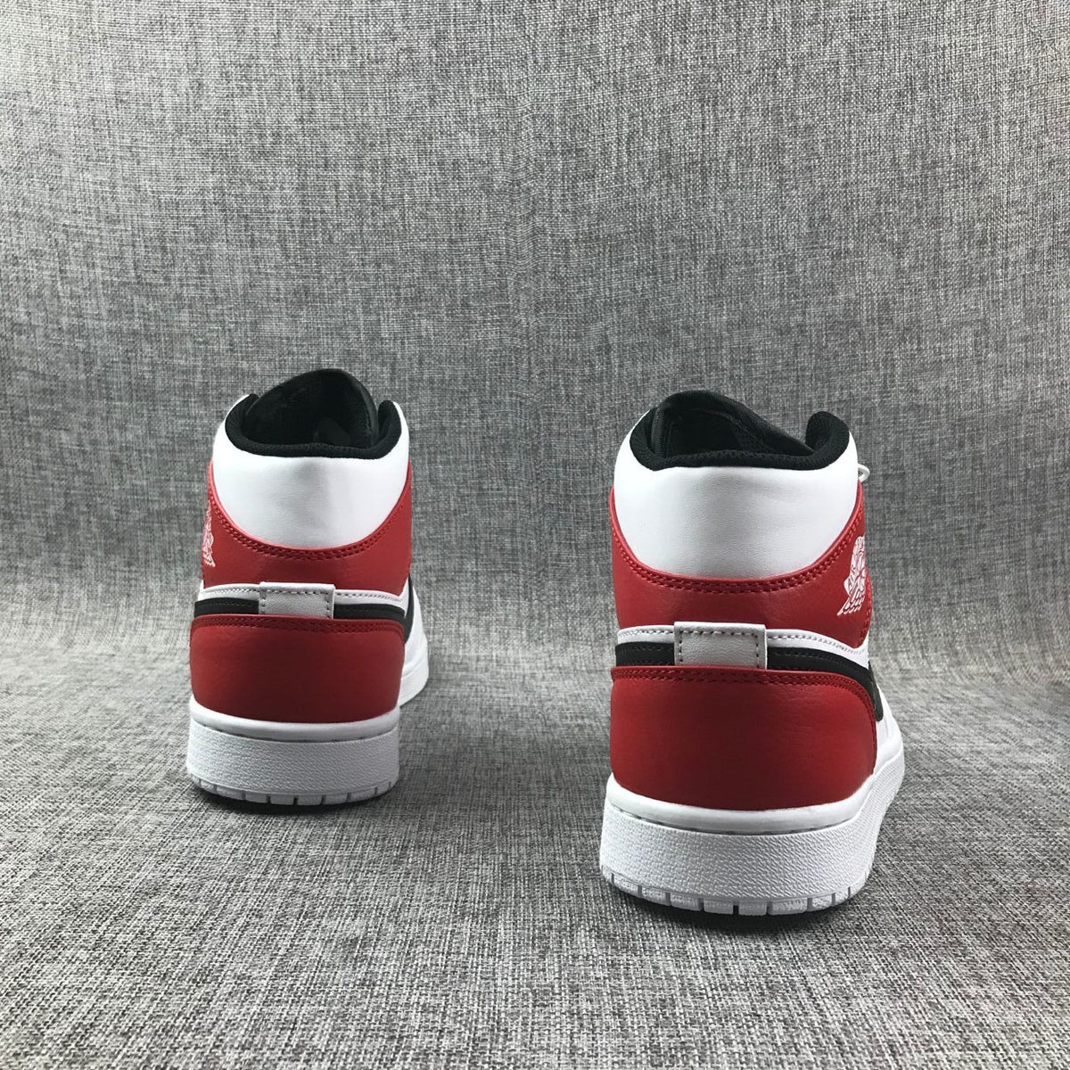 Rear view of the pair showing red heel panels, white collars, and black inner lining.