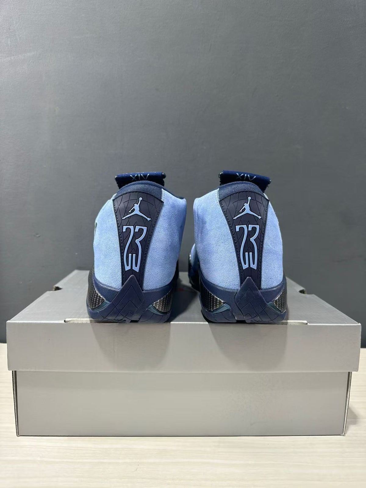 Rear view showing the Jordan Air Jordan 14 heel panels, XXIV markings, and contrasting blue and navy details.