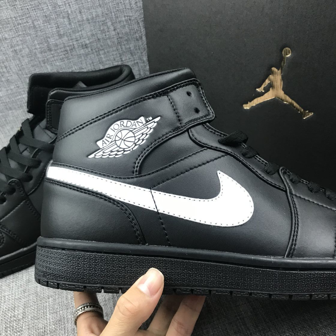 Detailed side view of the white Swoosh, black upper panels and winged collar branding.