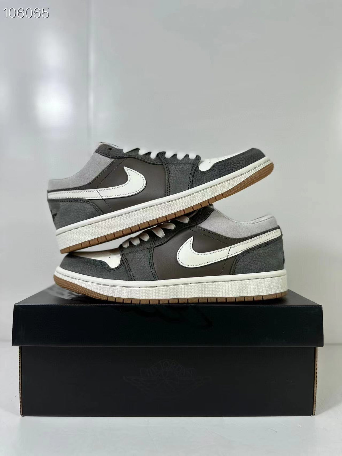 Stacked view of the low-top sneakers showing the contrasting side Swoosh, white midsoles and gum outsoles.