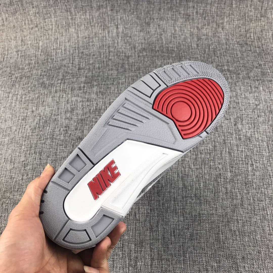 Close-up of the grey and red outsole with a white midfoot section and red Nike branding.