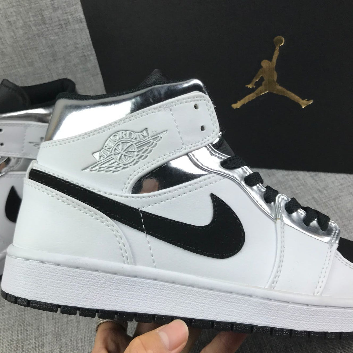 Close-up of the ankle area with the embossed Jordan Wings-style logo, black Swoosh, and metallic silver panels.