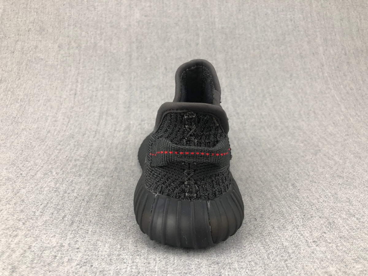 Rear view of a black sneaker showing the padded collar, heel pull tab, and red stitching.