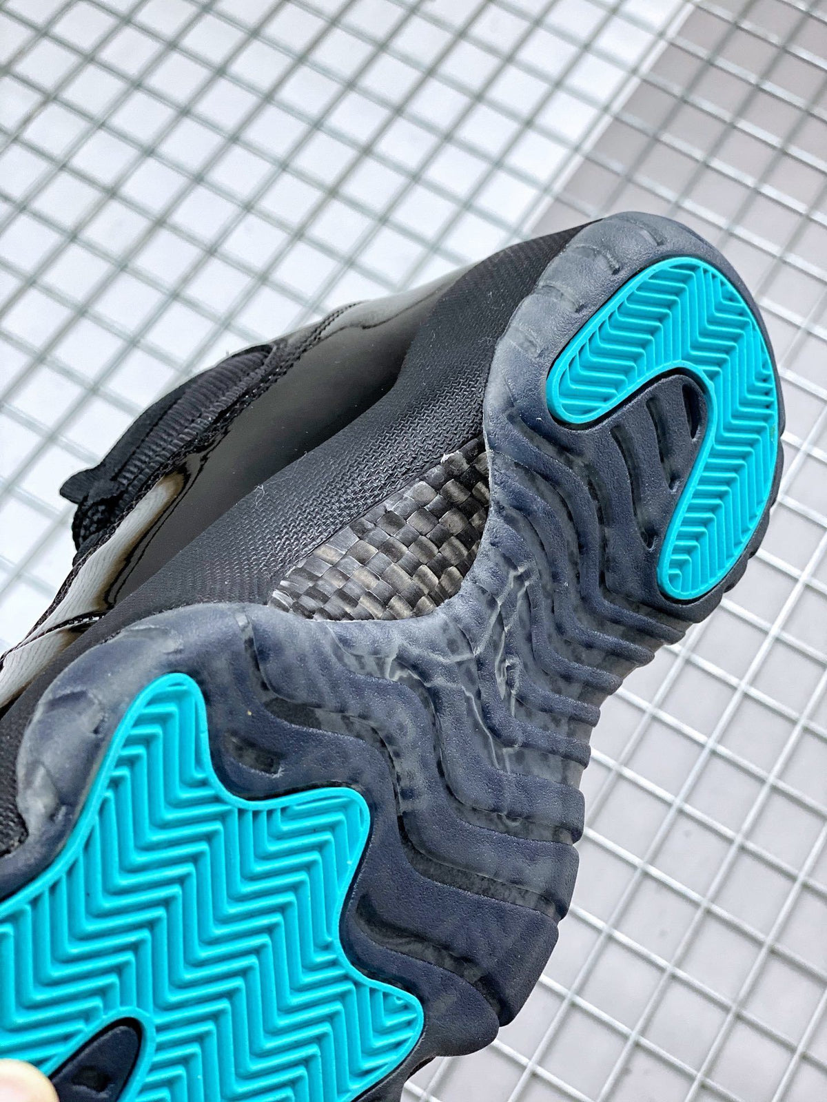 Underside detail showing dark translucent outsole sections with bright blue herringbone traction areas.