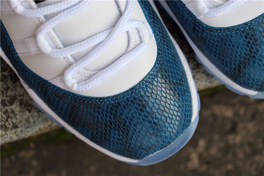 Close-up view of the navy patterned toe box and white laces.