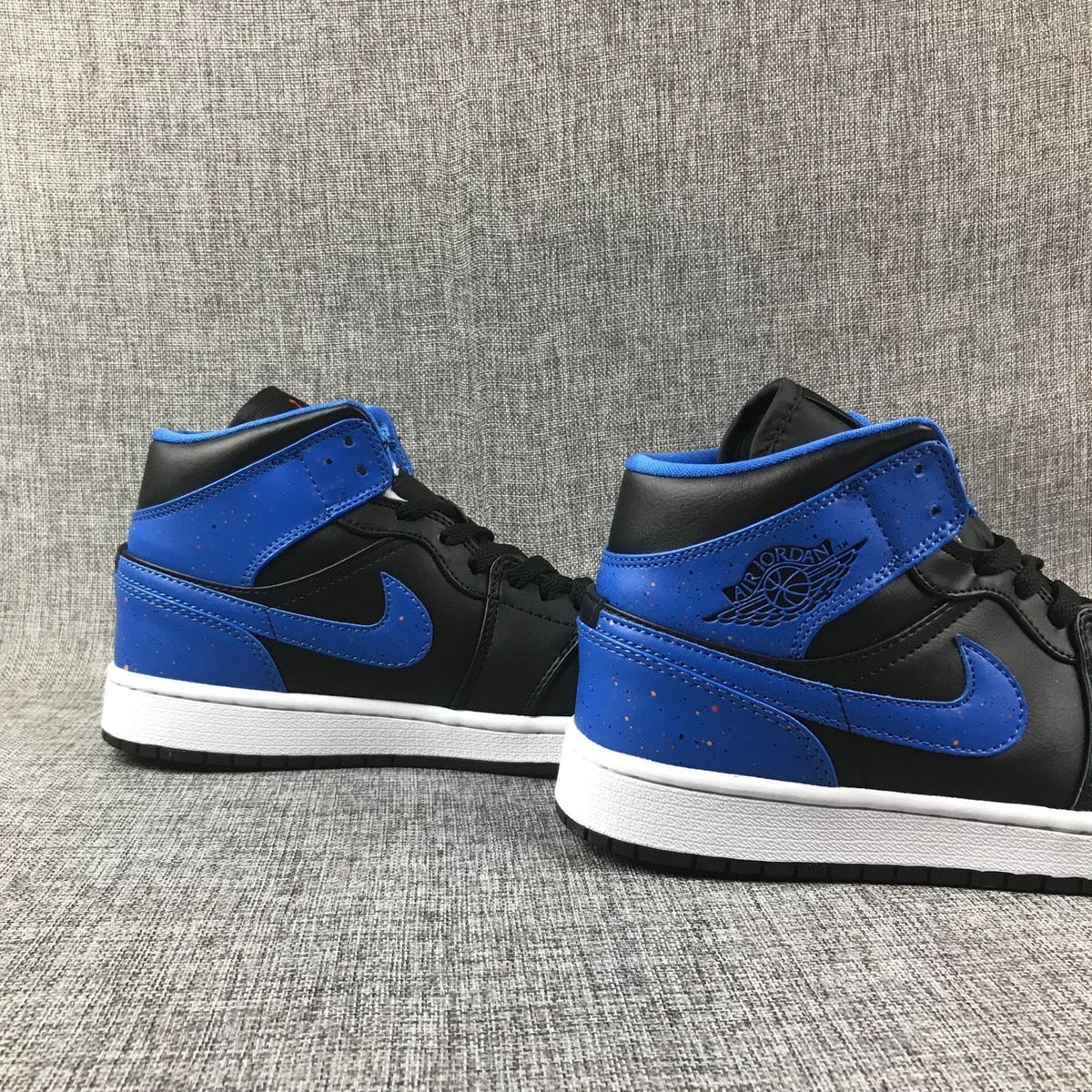 Pair of black and blue high-top sneakers shown from the rear-side angle.
