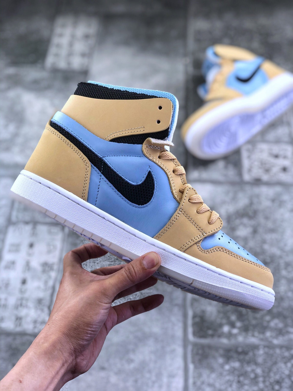 Side profile of the tan and light blue high-top sneaker with black Swoosh and layered panel construction.