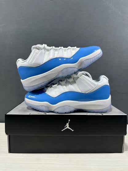 Pair of white and blue low-top sneakers arranged on a black Jordan shoe box.