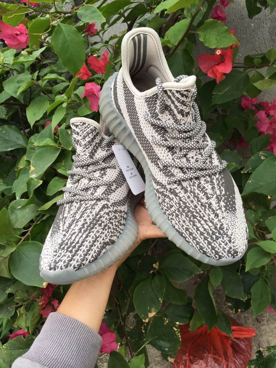 Angled front view of the gray and off-white knit sneaker pair.