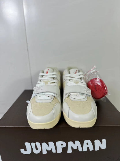 Front view of the matching sneakers showing cream mesh panels, white laces, forefoot straps, and extra red laces.