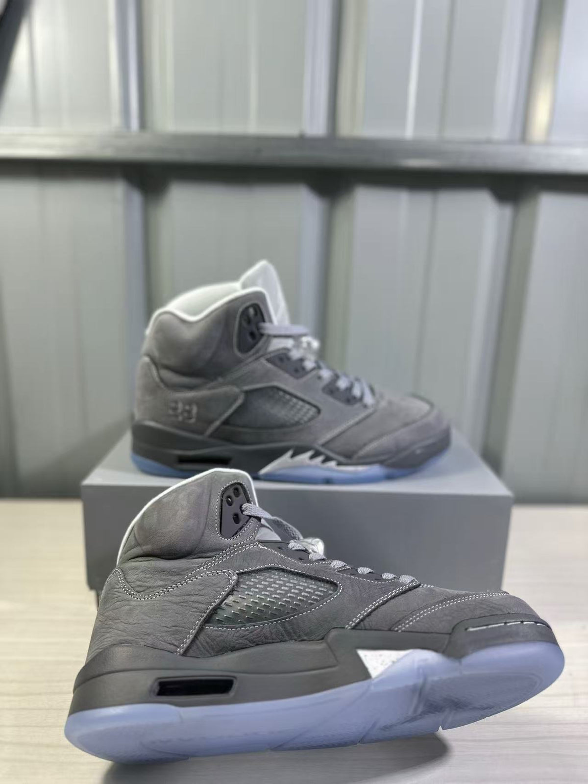 Angled close-up of a grey high-top sneaker highlighting the textured upper, side panel, padded collar, and translucent outsole.
